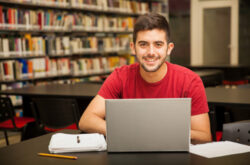 portrait-attractive-latin-student-doing-some-school-work-with-laptop-library
